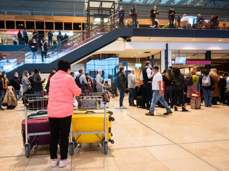 Passagiere warten in der Flughafenhalle auf ihre Abfertigung.