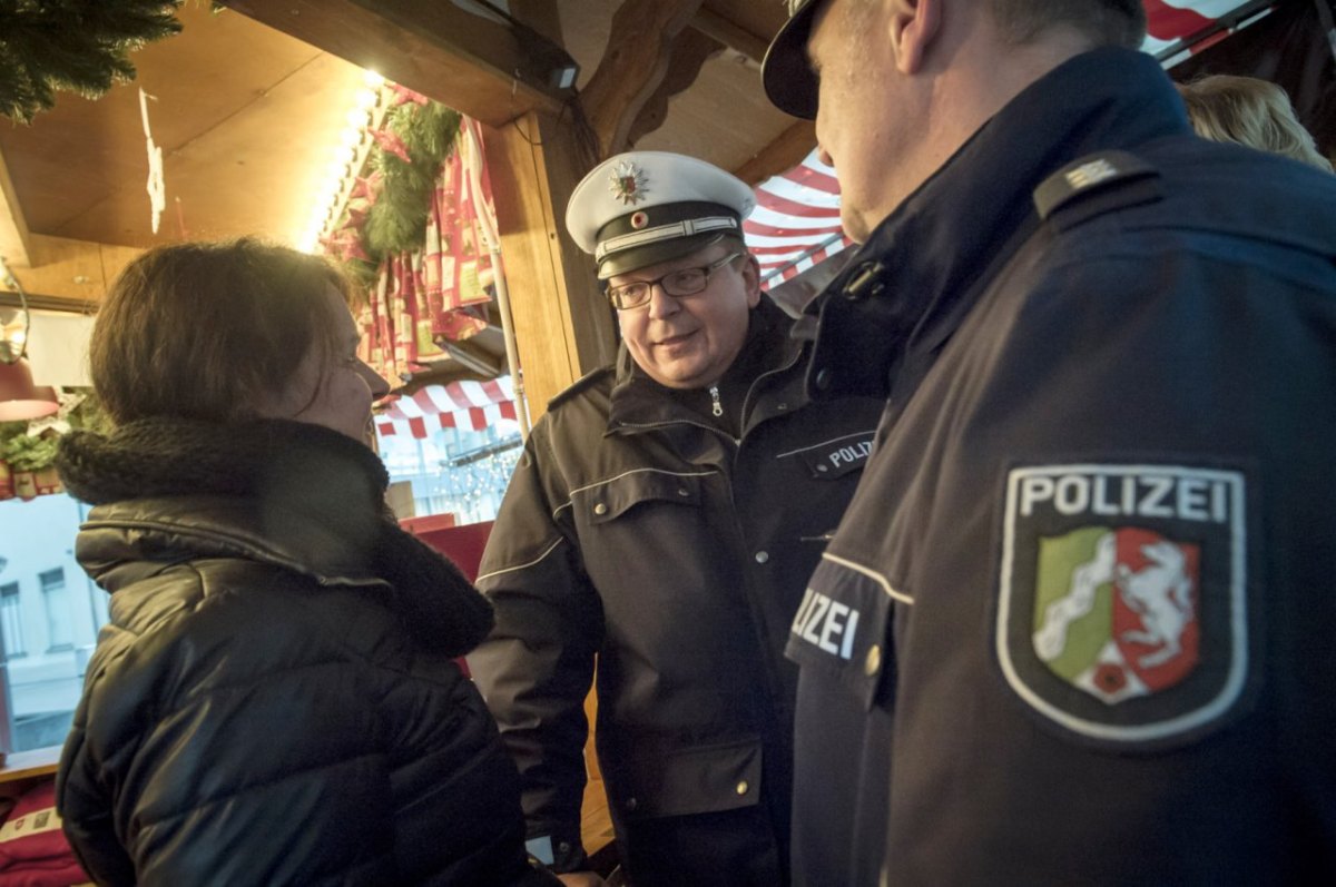 Polizist Uwe Weidmann informiert die Besucher des Duisburger Weihnachtsmarktes über Taschendiebe.jpg