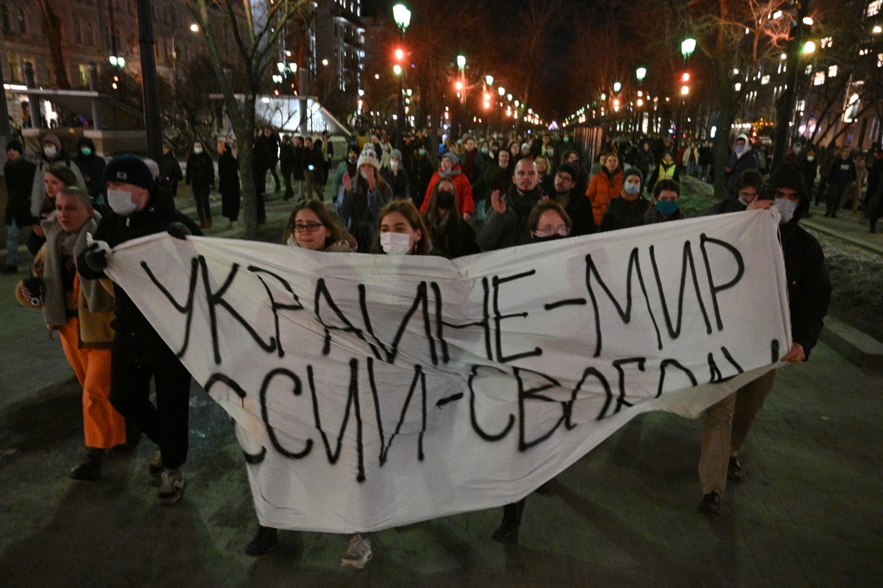 Demonstranten ziehen während eines Protests gegen Russlands Angriff auf die Ukraine mit einem Banner, auf dem „Ukraine – Frieden, Russland – Freiheit“ steht, durch die Straße