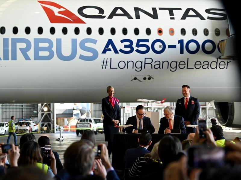 Qantas-CEO Alan Joyce (M, l) und Airbus-CEO Christian Scherer (M, r). Die australische Fluggesellschaft Qantas will ab Ende 2025 die längsten Nonstop-Flüge der Welt in ihr Streckennetz aufnehmen.