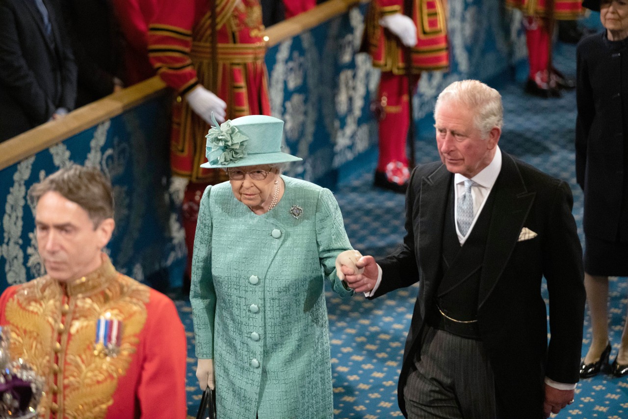 Queen Elizabeth II. wird von ihrem Sohn Prinz Charles aus dem Saal geführt. (Archivbild)
