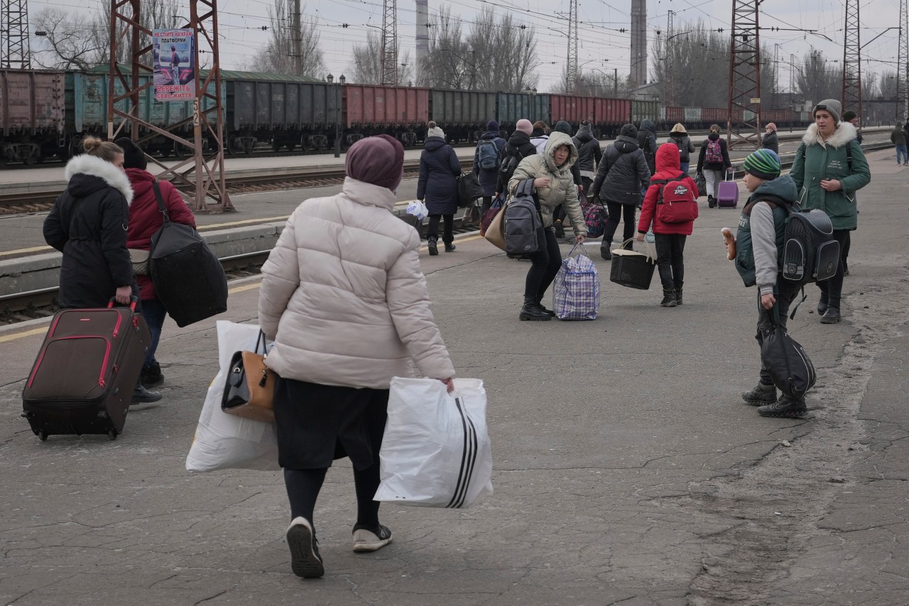 Ukraine, Kostiantynivka: Menschen, die auf einen nach Kiew fahrenden Zug warten, verteilen sich auf einem Bahnsteig in Kostiantynivka in der Region Donezk in der Ostukraine.