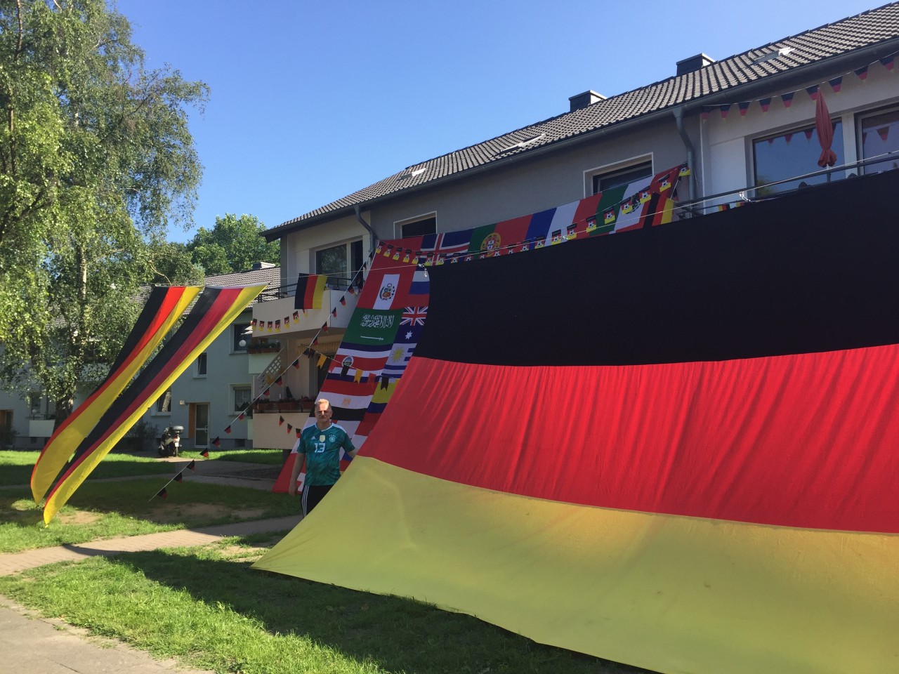 Drei riesige Deutschland-Fahnen und seine selbstgenähte WM-Fahne zieren seinen Vorgarten.