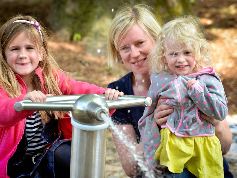 Auf dem Wasserspielplatz am Hallenbad in Gladbeck spielen Nele (6), Mutter Iris Rösner und Schwester Lina (3).