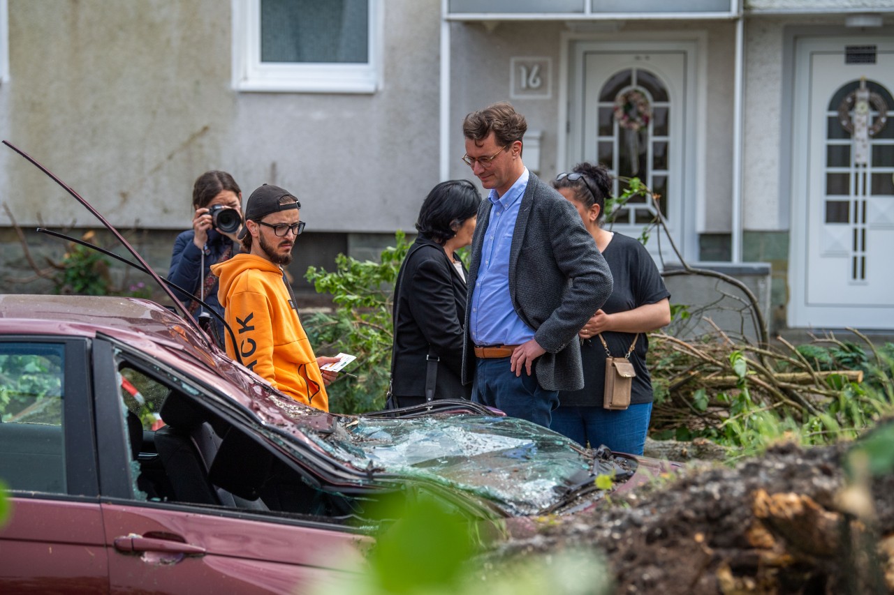 Hendrik Wüst spricht in Lippstadt mit einem Anwohner, dessen Auto durch den Sturm zerstört wurde.