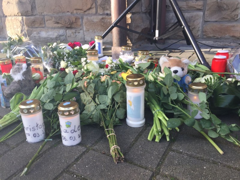 Vor der Kirche haben Menschen Kerzen aufgestellt und Blumen niedergelegt.
