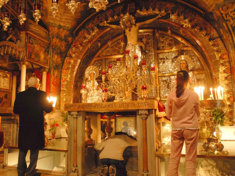 Die Golgotakapelle mit dem griechisch-orthodoxen Kreuzigungsaltar in der Grabeskirche. Das aramäische Wort Golgota (Golgatha) bedeutet Schädel, die Bezeichnung für eine Felsformation, die die Form eines Schädels aufwies. Zwischen den Säulen, die die Altarplatte tragen, befindet sich das Felsloch, in dem das Kreuz gestanden haben soll, an dem Jesus starb. Viele Gläubige kriechen an diese Stelle unter die Altarplatte. Die Kapelle ist die 14. Station der Via Dolorosa.