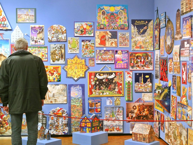 Besucher in der Adventskalender-Ausstellung bewundern die bunte Vielfalt.