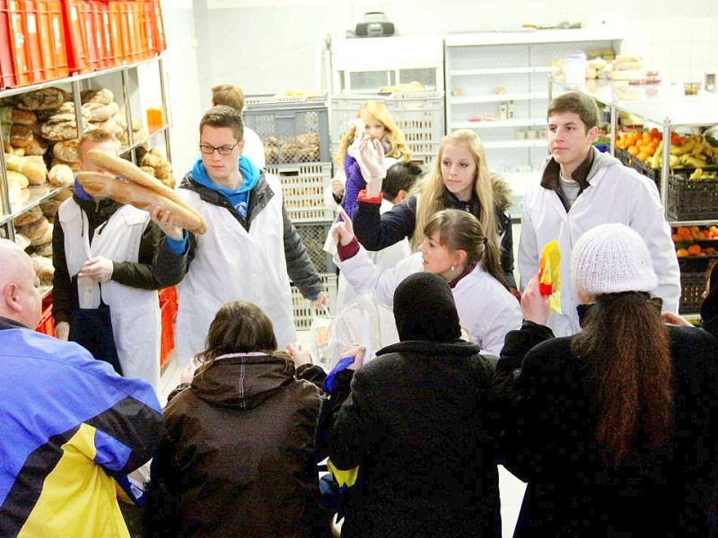 Schüler des Otto Pankok Gymnasiums in Mülheim haben am 22.12.2011 einen Tag lang bei der Mülheimer Tafel mitgeholfen. Sie haben die Lieferwagen mit entladen, die Lebensmittel in die Regale geräumt und anschließend die Lebensmittel an die Bedürftigen verteilt.erstin Bögeholz / WAZ FotoPool