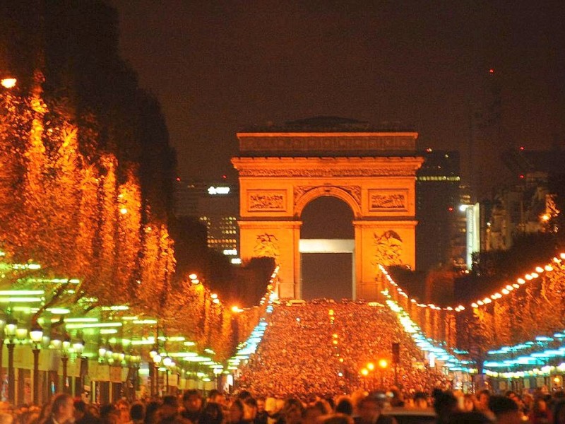 ...ist die Prachtmeile Champs-Elysées in der Silvesternacht hell erleuchtet. Hier und vor dem Eiffelturm haben sich...