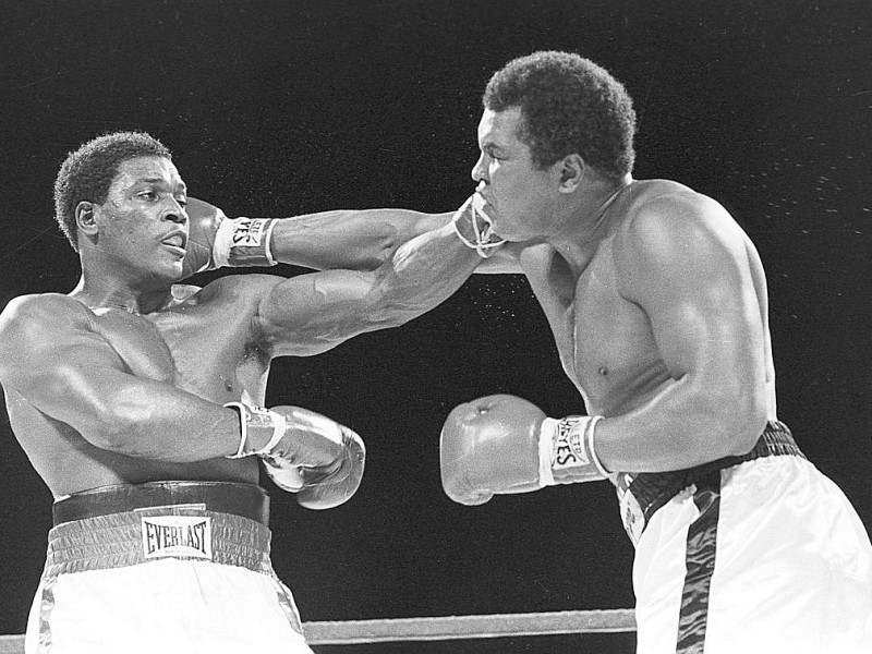 Trevor Berbick (l.) und Muhammad Ali treffen beide gleichzeitig ihren Gegner beim Kampf in Nassau, Bahamas. (AP Photo/File)