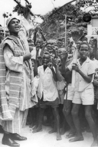 1964: Muhammad Ali trägt traditionelle nigerianische Kleidung bei seiner Ankunft in Lagos. (AP Photo/File)