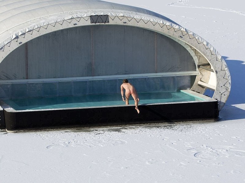 ...steigt von einem Berliner Saunaschiff in in die gefrorene Spree. Nicht weit entfernt...