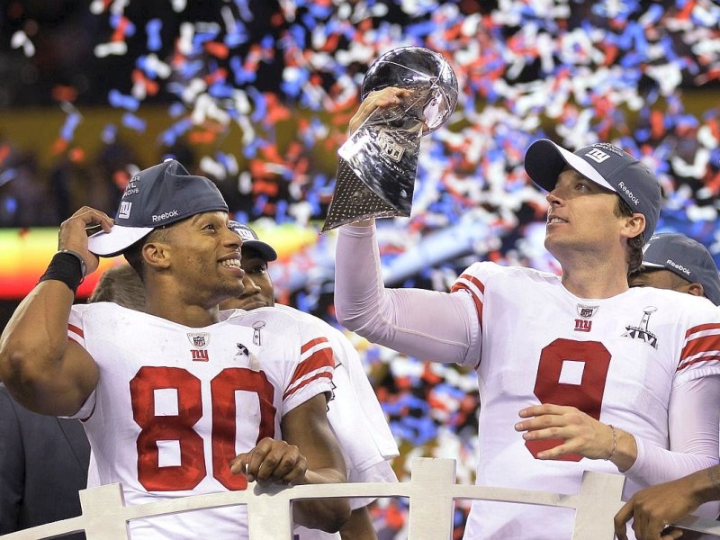 New York Giants wide receiver Victor Cruz (80) and kicker Lawrence Tynes (9) celebrate with the Vince Lombardi Trophy after the Giants' 21-17 win over the New England Patriots in NFL Super Bowl XLVI football game, Sunday, Feb. 5, 2012, in Indianapolis. (AP Photo/Mark Humphrey)