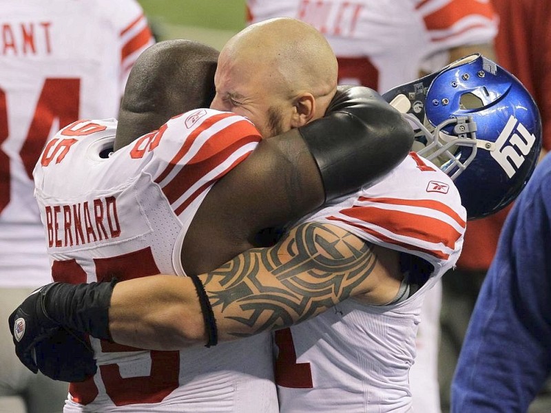 New York Giants defensive tackle Rocky Bernard, left, hugs Dave Tollefson, right, after the NFL Super Bowl XLVI football game against the New England Patriots, Sunday, Feb. 5, 2012, in Indianapolis. The Giants won 21-17. (AP Photo/Elise Amendola)