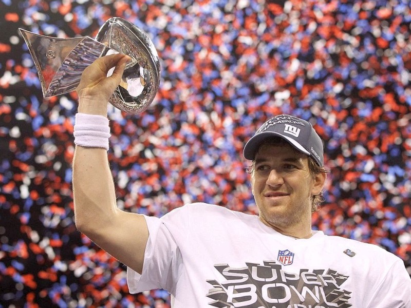New York Giants quarterback Eli Manning holds the Vince Lombardi Trophy after defeating the New England Patriots in the NFL Super Bowl XLVI football game in Indianapolis, Indiana, February 5, 2012. REUTERS/Jeff Haynes (UNITED STATES  - Tags: SPORT FOOTBALL)
