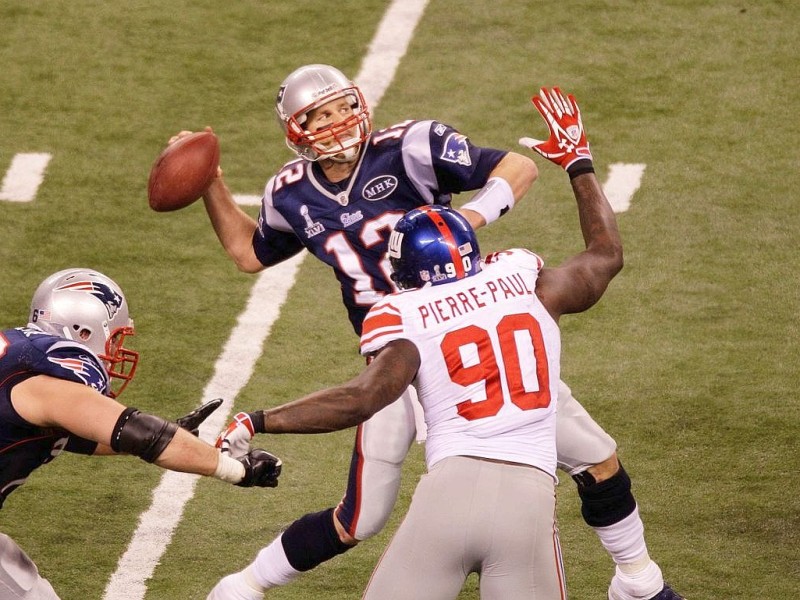 New England Patriots quarterback Tom Brady (12) throws the last pass of the game as New York Giants defensive end Jason Pierre-Paul (90) defends during the second half of the NFL Super Bowl XLVI football game, Sunday, Feb. 5, 2012, in Indianapolis. (AP Photo/Charlie Riedel)