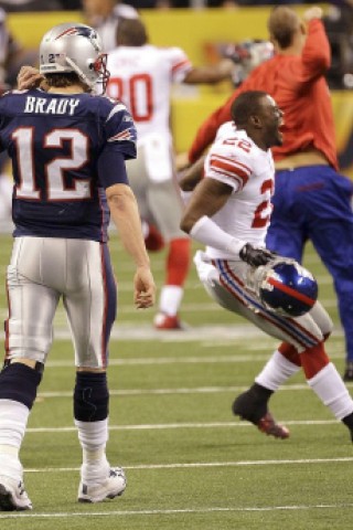 New York Giants defensive back Derrick Martin (22) celebrates as New England Patriots quarterback Tom Brady leaves the field after the NFL Super Bowl XLVI football game, Sunday, Feb. 5, 2012, in Indianapolis. The Giants won 21-17. (AP Photo/Pat Semansky)