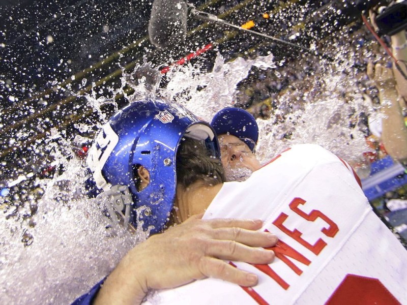 New York Giants kicker Lawrence Tynes hugs head coach Tom Coughlin as they get doused with liquid at the end of the NFL Super Bowl XLVI football game against the New England Patriots, Sunday, Feb. 5, 2012, in Indianapolis. The Giants won 21-17. (AP Photo/David J. Phillip)