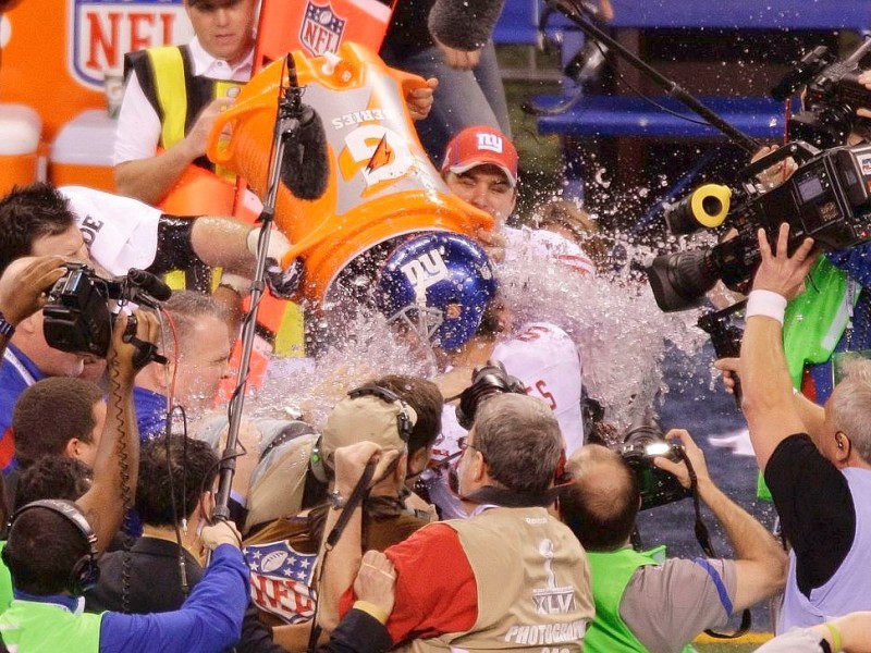 New York Giants head coach Tom Coughlin, not seen, is doused with liquid after the team defeated the New England Patriots 21-17 in the NFL Super Bowl XLVI football game, Sunday, Feb. 5, 2012, in Indianapolis. (AP Photo/Charlie Riedel)