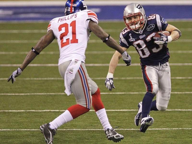 New England Patriots wide receiver Wes Welker (83) runs with the ball as he tries to avoid New York Giants strong safety Kenny Phillips (21) during the second half of the NFL Super Bowl XLVI football game, Sunday, Feb. 5, 2012, in Indianapolis. (AP Photo/Elise Amendola)