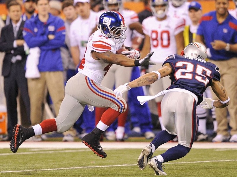 Ahmad Bradshaw (L) of the New York Giants tries to elude the tackle from Patrick Chung (R) of the New England Patriots in the first quarter of Super Bowl XLVI on February 5, 2012 at Lucas Oil Stadium in Indianapolis, Indiana. AFP PHOTO / TIMOTHY A. CLARY