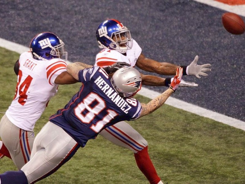 New England Patriots tight end Aaron Hernandez (81) can't make the reception as New York Giants safety Deon Grant (34) and Jacquian Williams defend during the second half of the NFL Super Bowl XLVI football game, Sunday, Feb. 5, 2012, in Indianapolis. (AP Photo/Charlie Riedel)