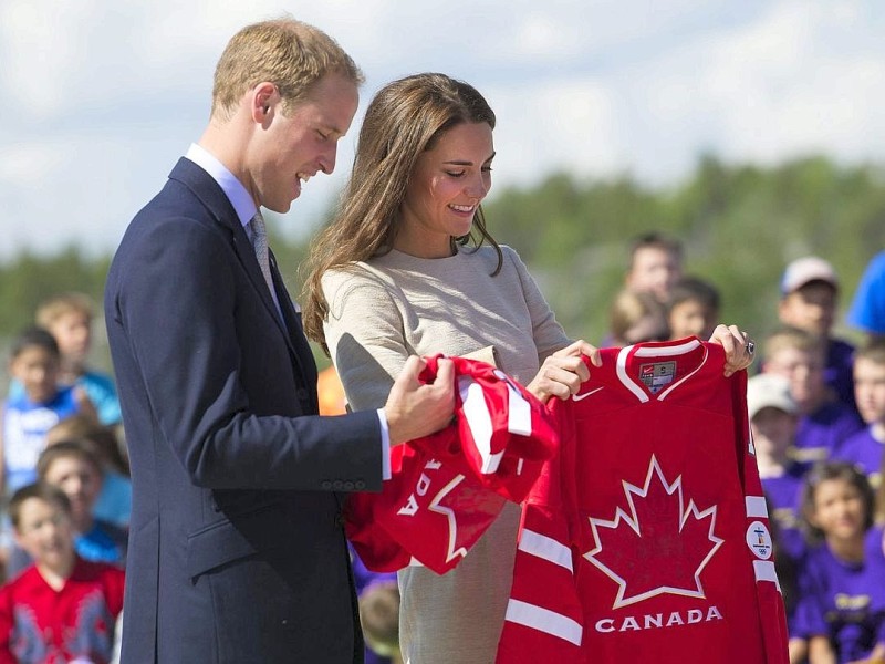 Prinz William und Kate halten Hockey-Trikots der kanadischen Mannschaft in den Händen.