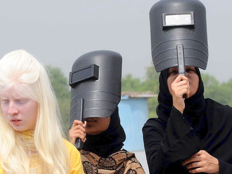 Die pakistanischen Studentinnen schützen sich mit Schweißer-Masken vor den Sonnenstrahlen.