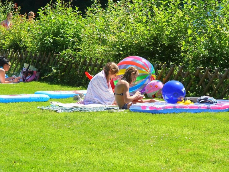 Auch in Hattingen entspannen die jungen Mädchen im Freibad in der Sonne.