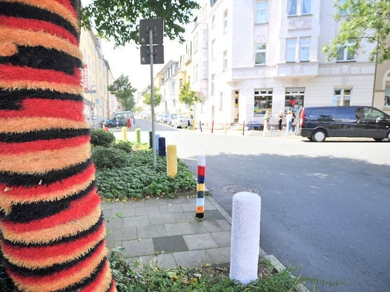 Bestrickte Begrenzungspoller, bunte Baumkleider und ein neuer Strickgarten machen die Emmastraße, Ecke Reginenstraße in Rüttenscheid ein bisschen farbenfroher. Foto: Sebastian Konopka
