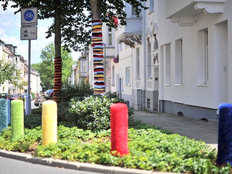 Bestrickte Begrenzungspoller, bunte Baumkleider und ein neuer Strickgarten machen die Emmastraße, Ecke Reginenstraße in Rüttenscheid ein bisschen farbenfroher. Foto: Sebastian Konopka