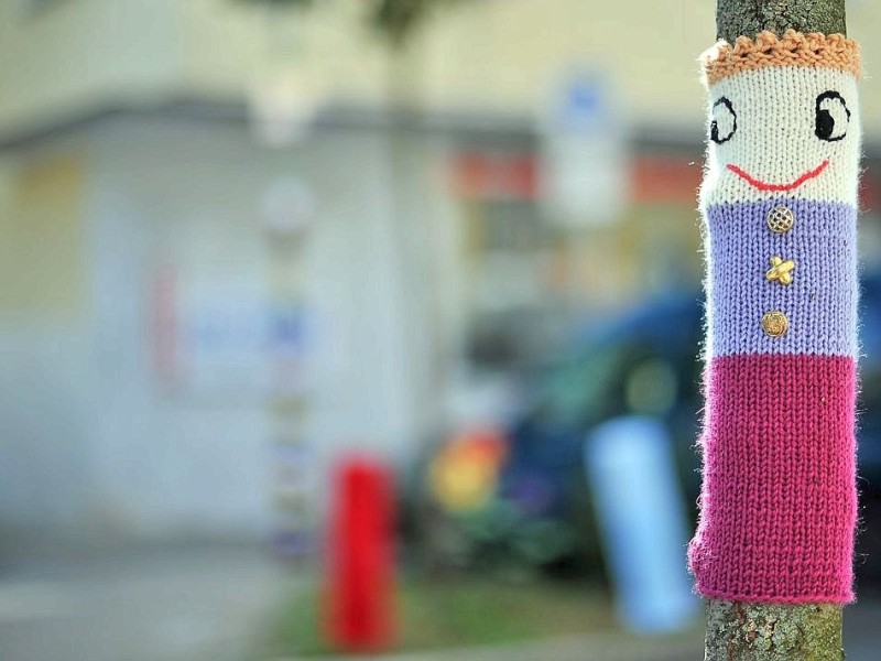 Bestrickte Begrenzungspoller, bunte Baumkleider und ein neuer Strickgarten machen die Emmastraße, Ecke Reginenstraße in Rüttenscheid ein bisschen farbenfroher. Foto: Sebastian Konopka