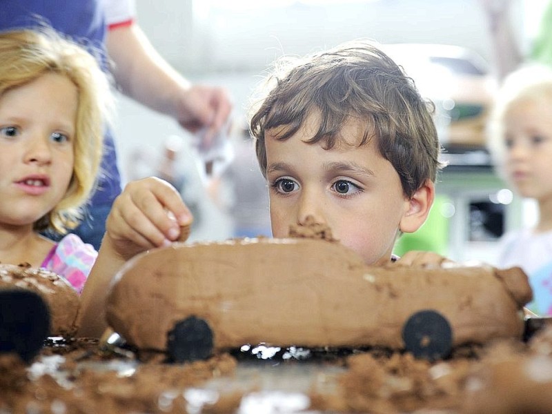 Aus Ton Modell-Autos formen, oder eine neue Linienform entwerfen; ein kleiner Junge experimentiert mit Formen. Foto: Matthias Graben / WAZ FotoPool