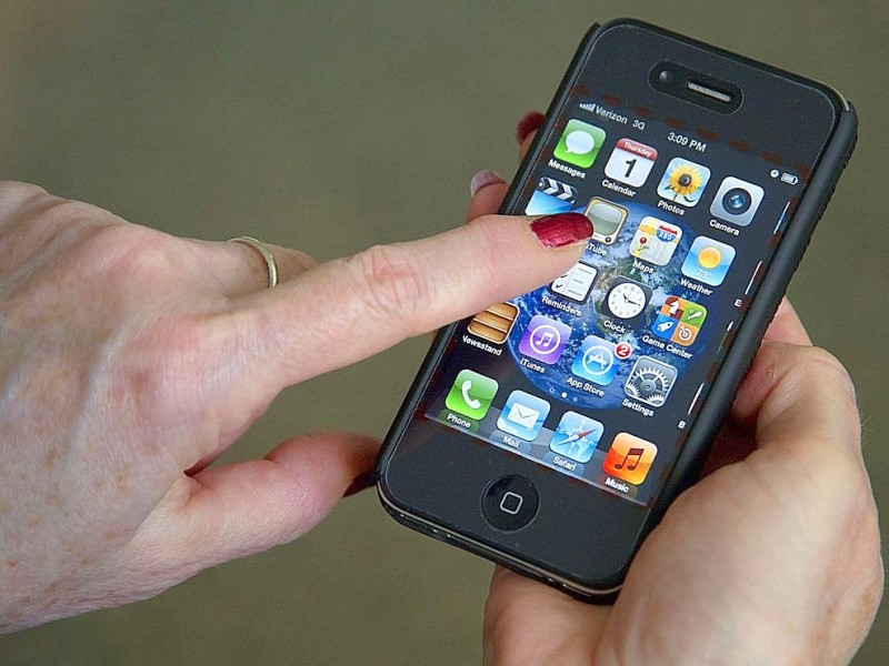 Weltweit typische Bewegung: Eine Frau benutzt den Touchscreen ihres iPhones.