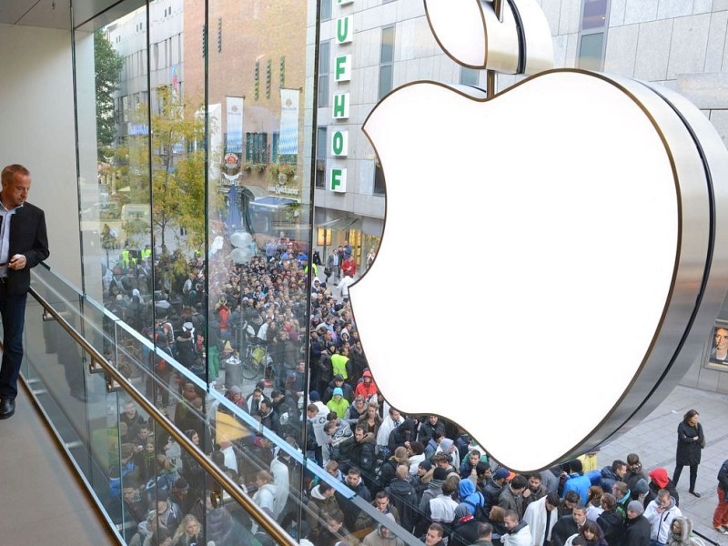 Customers queue to enter the Apple Store where a giant logo is displayed in the southern German city of Munich on September 21, 2012 as the iPhone 5 goes on sale. AFP PHOTO/CHRISTOF STACHE