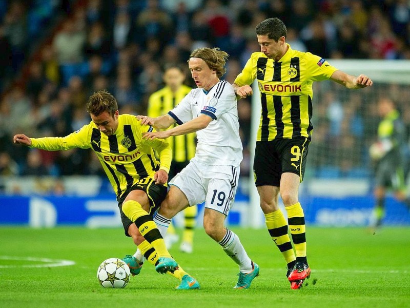 MADRID, SPAIN - NOVEMBER 06: Mario Gotze (L) and  Robert Lewandowski (R) of Borussia Dortmund duel for the ball with Luka Modric of Real Madrid during the UEFA Champions League group D match between Real Madrid and Borussia Dortmund at Estadio Santiago Bernabeu on November 6, 2012 in Madrid, Spain.  (Photo by Jasper Juinen/Getty Images)