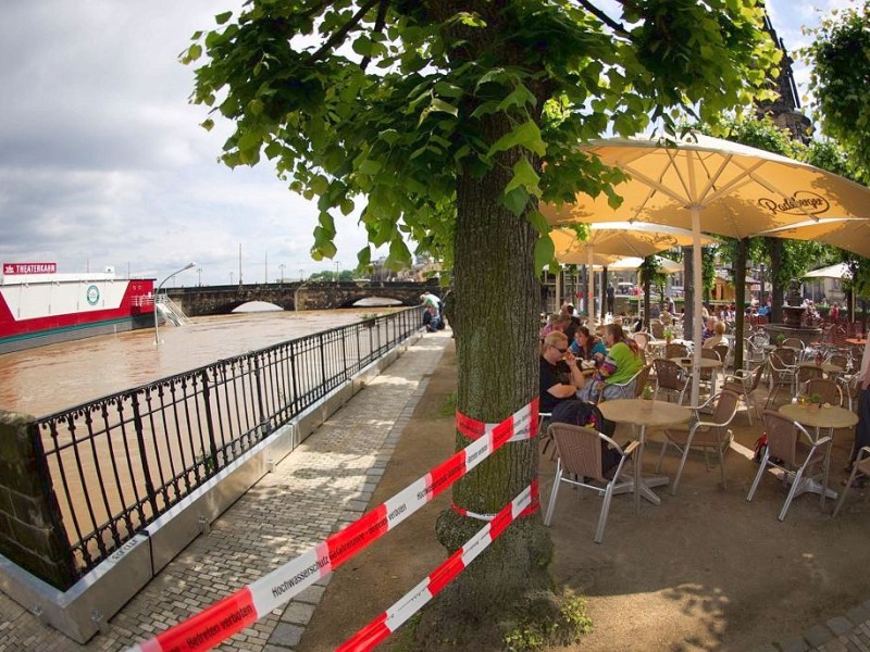 Die Gäste in dem Café lassen sich ihren Alltag vom Hochwasser am Elbufer in Dresden nicht kaputt machen...