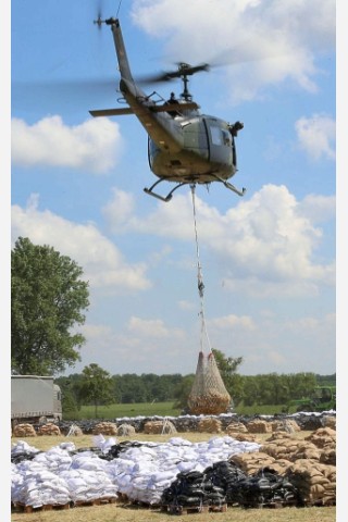 Ein Hubschrauber der Bundeswehr transportiert neue Sandsäcke zu den Deichen.