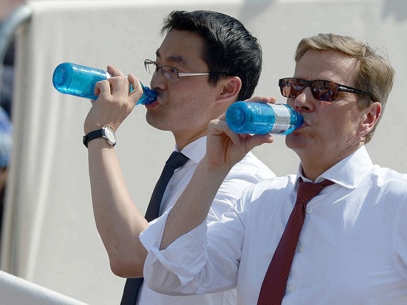 Aber auch andere Politiker kämpfen gegen die Hitze. Guido Westerwelle und Philipp Rösler kühlen sich mit einem großen Schluck Wasser ab.