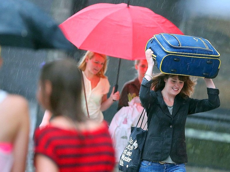 Menschen gehen in Köln durch den Regen.