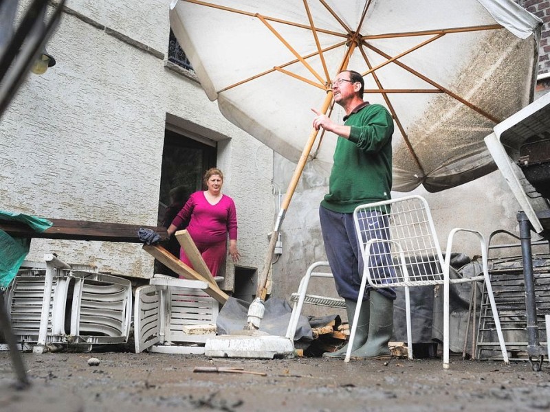 Mümin Yasalar und seine Frau Hülya vor ihrem Haus. Eine Tag nach dem Unwetter sind Bewohner dabei die Schäden zu sichten und mit den Aufräumungsarbeiten zu beginnen. Wie hier in Witten in der Herbeder Straße hat der Regen deutliche Spuren hinterlassen.