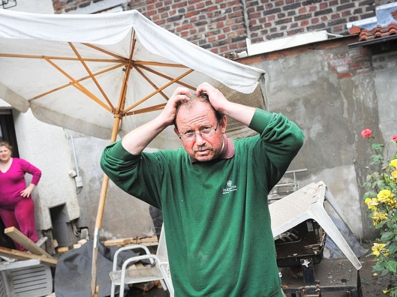 Mümin Yasalar und seine Frau Hülya vor ihrem Haus. Eine Tag nach dem Unwetter sind Bewohner dabei die Schäden zu sichten und mit den Aufräumungsarbeiten zu beginnen. Wie hier in Witten in der Herbeder Straße hat der Regen deutliche Spuren hinterlassen.