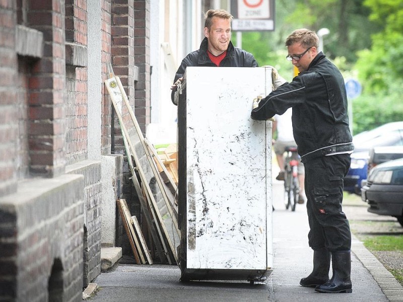 Ab in den Sperrmüll: Am Tag nach dem Unwetter sind Bewohner dabei die Schäden zu sichten und mit den Aufräumungsarbeiten zu beginnen. Wie hier in Witten in der Herbeder Straße hat der Regen deutliche Spuren hinterlassen.