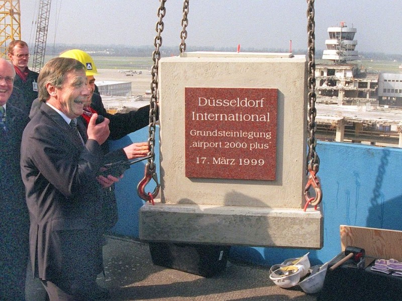 In Anwesenheit des nordrhein-westfälischen Ministerpräsidentens Wolfgang Clement wird am 17. März 1999 der Grundstein für Airport 2000 plus gelegt. Noch im selben Monat beginnen die Rohbauarbeiten.