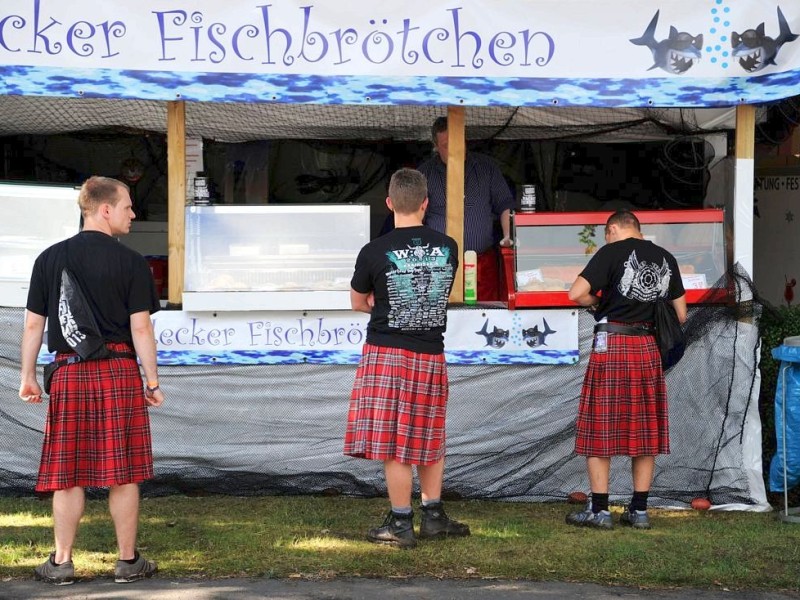 Festival-Besucher stehen in Wacken an einem Verkaufsstand für Fischbrötchen.