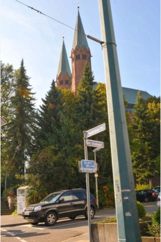 Rechts erheben sich die Türme der neuromanischen Nikolauskirche, die hier seit 1907 am Fuß des Stoppenberger Kapitelbergs steht. Die Kirche wurde ab 1904 gebaut, weil die Gemeinde im industriell aufkeimenden Essen immer weiter wuchs.