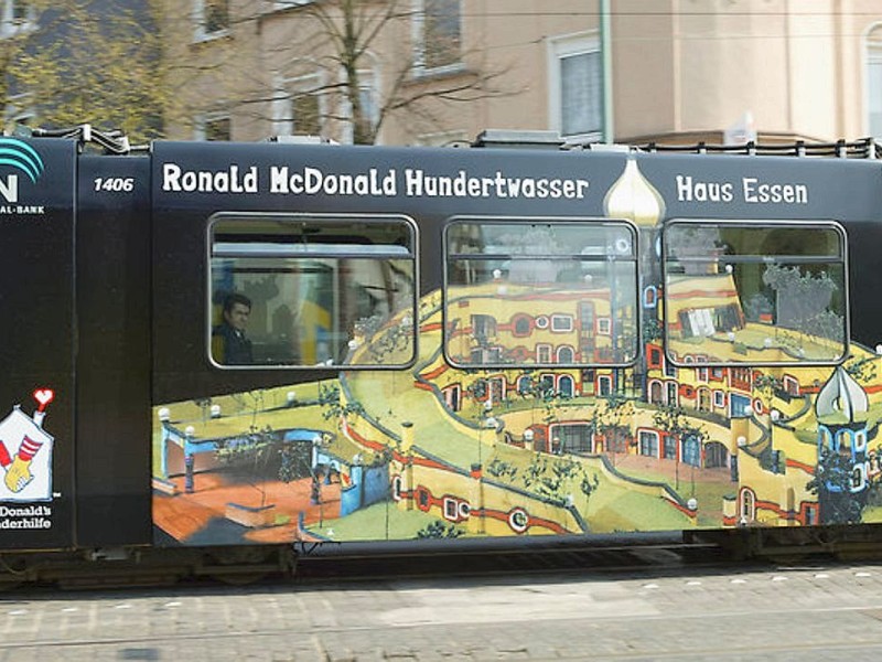 Eine EVAG-Straßenbahn wirbt für das Hundertwasser-Haus der McDonalds-Kinderhilfe, das in der Gruga entstehen soll.