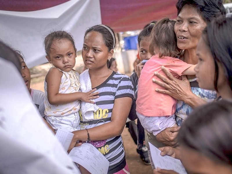 Hilfsorganisationen bauen und organisieren ein Flüchtlingslager / Unterkunft in Estancia. Die Katastrophenhelferin Lucile von ACF führt Angelika Böhling durch die Unglücksgebiete 28.11.2013 auf der Insel Panay - Phillippinen    Bild: Jakob Studnar