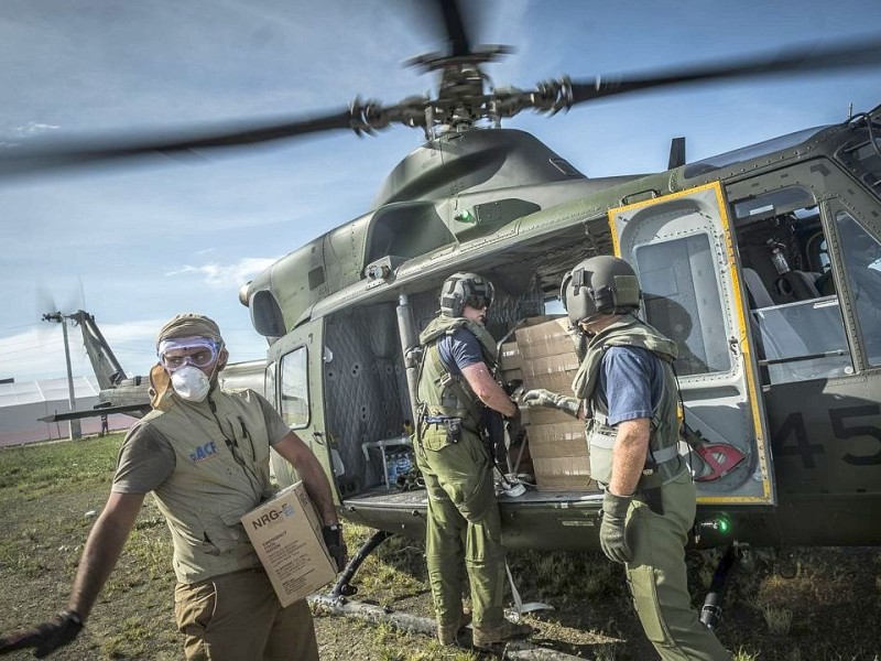 Katastrophenhelfer von ACF, einer Partnerorganisation der Kindernothilfe beladen einen Hubschrauber der Kanadischen Armee mit Nahrungspaketen. Die Notfallnahrung versorgt die Menschen für 14 Tage. Die Kanadische Armee fliegt die Hilfsgüter un unzugängliche Gebiete in den Bergen.  Die Katastrophenhelferin Lucile von ACF führt Angelika Böhling durch die Unglücksgebiete 28.11.2013 auf der Insel Panay - Phillippinen    Bild: Jakob Studnar